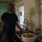 Franz vom Asa-FF wäscht Kartoffeln vor der Spüle und lacht.