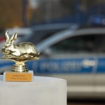 Goldener Hasenpokal mit Polizeidienstagen im Hintergrund