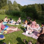 Gemeinsames Sonnenbaden auf Decken am Fluss