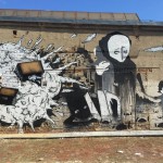 Wandgraffiti mit zerbombtem Haus, burkatragender Frau mit totem Kind über der Schulter und Sohn an der Hand mit müdem Blick.