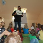 Mehrdad Zaeri hält vor den Kindern im Kindergarten ein Bild hoch