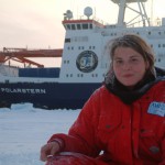Bild von Dr Julianne Müller vor dem Expeditionsschiff Polarstern in der Arktis