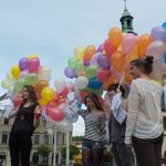 Vier Aktionsteilnehmerinnen mit zusammengebundenen Ballons und vielen vollgeschriebenen Karten daran in der Hand auf dem Zwickauer Marktplatz