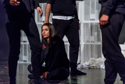 Schauspielerin sitzt auf dem Boden zwischen drei anderen Schauspielenden