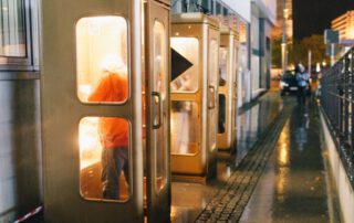 Drei goldene Zelefonzellen stehen in Regen und sind gerade besetzt