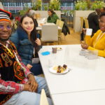 Drei Menschen sitzen am Tisch.