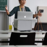 Eine Frau aus Vietnam hält einen Vortrag. Vor ihr steht ein Computer auf einem Stehpult.