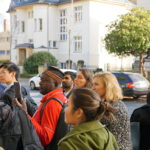 Eine Gruppe Menschen befindet sich draußen vor einem Gebäude.