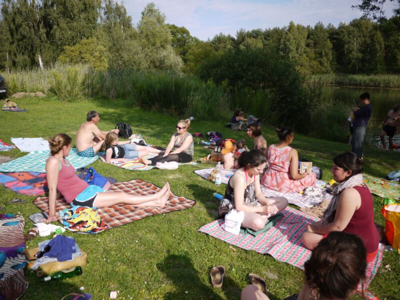 Gemeinsames Sonnenbaden auf Decken am Fluss