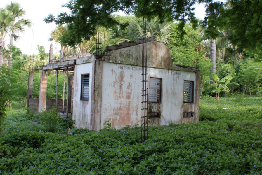 Verfallenes Haus auf dem steht: "Philippine German Special Energy Program". Zeigt Kritik an wenig Nachhaltigkeit bei Energiewendeinvestitionen in Ländern des Globalen Südens.