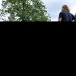 Teilnehmende liegen auf Decken auf der Wiese und schauen zu den stehenden Asa Mitarbeitern