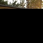 Blick auf den Balkon einer Unterkunft von einer schönen zugewachsenen Wiese