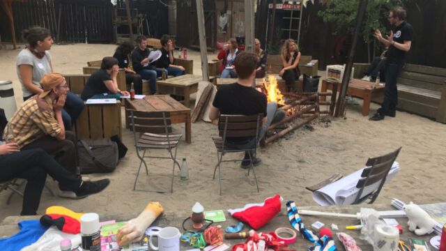 Foto: Hai-Hsin Lu Teilnehmende des Workshops sitzen im Hellen am Lagerfeuer