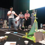 Teilnehmende in Showroom sind im Mittelpunkt mit offensichtlich selbstgebastelten Dingen