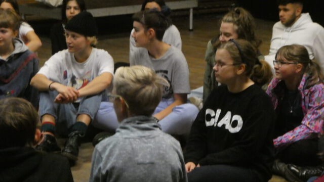 Schülerinnen und Schüler beim sitzen auf dem Boden in Nahaufnahme